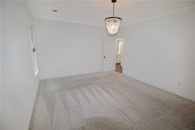 spare room featuring ornamental molding, light colored carpet, and an inviting chandelier