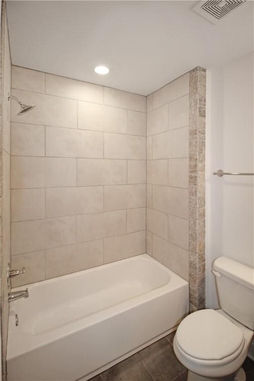 bathroom featuring tile patterned floors, toilet, and tiled shower / bath