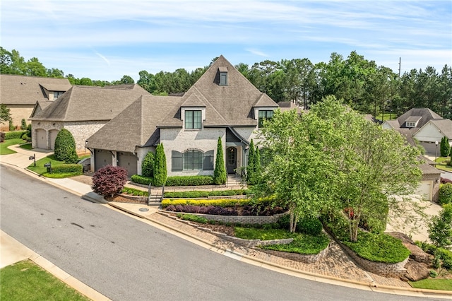 1569 Woodley Cir, Auburn, AL 36830 - french country style house featuring a garage, concrete driveway, and a shingled roof