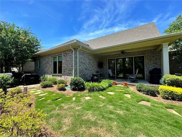 rear view of property with a patio, ceiling fan, and a lawn