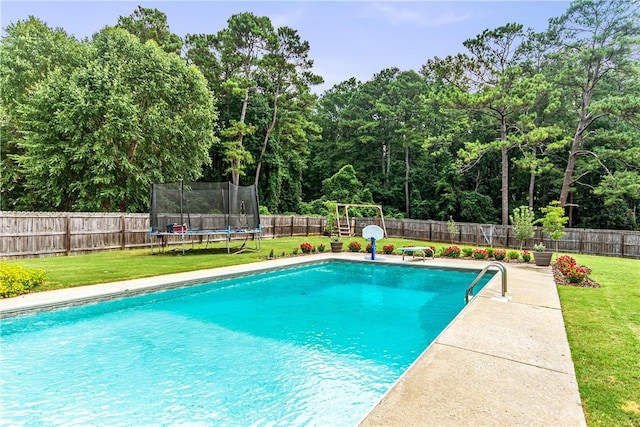 view of pool featuring a lawn and a trampoline