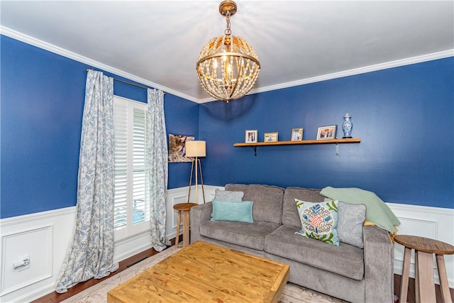 living room featuring wood-type flooring, ornamental molding, and an inviting chandelier