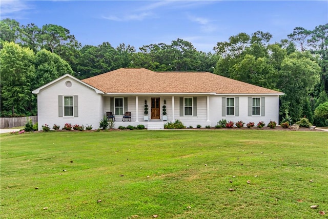 single story home featuring covered porch and a front yard