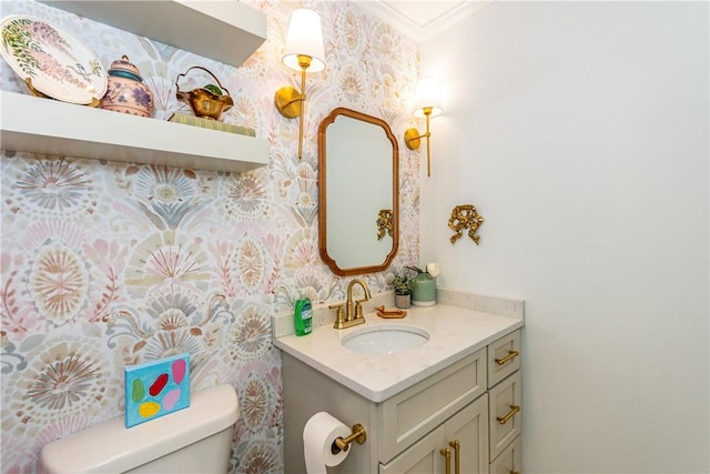 bathroom with vanity, toilet, and ornamental molding