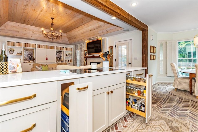 kitchen with white cabinetry, hanging light fixtures, a notable chandelier, a tray ceiling, and wood ceiling