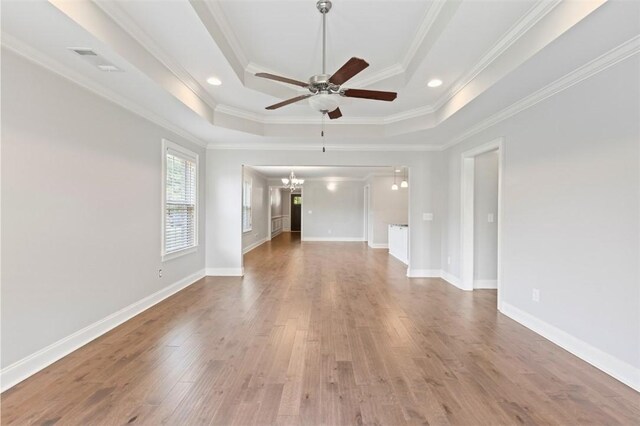 2375 Snowshill Ln, Auburn, AL 36832 - unfurnished living room featuring a chandelier, a raised ceiling, ceiling fan, wood finished floors, and crown molding
