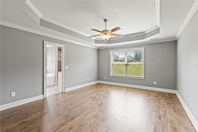2375 Snowshill Ln, Auburn, AL 36832 - empty room featuring a raised ceiling, ornamental molding, wood finished floors, ceiling fan, and baseboards