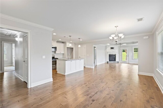 2375 Snowshill Ln, Auburn, AL 36832 - unfurnished living room featuring a chandelier, ornamental molding, baseboards, light wood-style floors, and recessed lighting