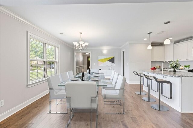2375 Snowshill Ln, Auburn, AL 36832 - dining area with crown molding, a chandelier, wood finished floors, and baseboards