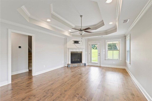 2375 Snowshill Ln, Auburn, AL 36832 - unfurnished living room featuring a ceiling fan, a raised ceiling, wood finished floors, a fireplace with raised hearth, and ornamental molding