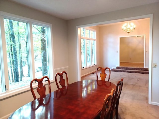 carpeted dining area featuring a notable chandelier