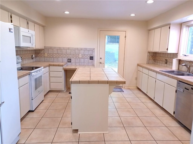 kitchen featuring white cabinetry, backsplash, a center island, white appliances, and sink