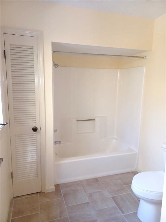 bathroom featuring toilet, tub / shower combination, and tile patterned floors