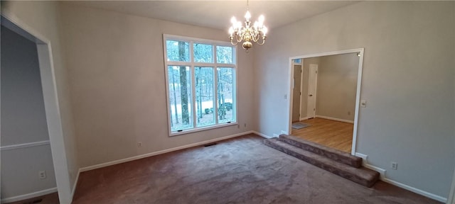 empty room featuring a wealth of natural light, carpet flooring, and an inviting chandelier