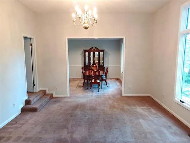 unfurnished dining area featuring carpet and an inviting chandelier