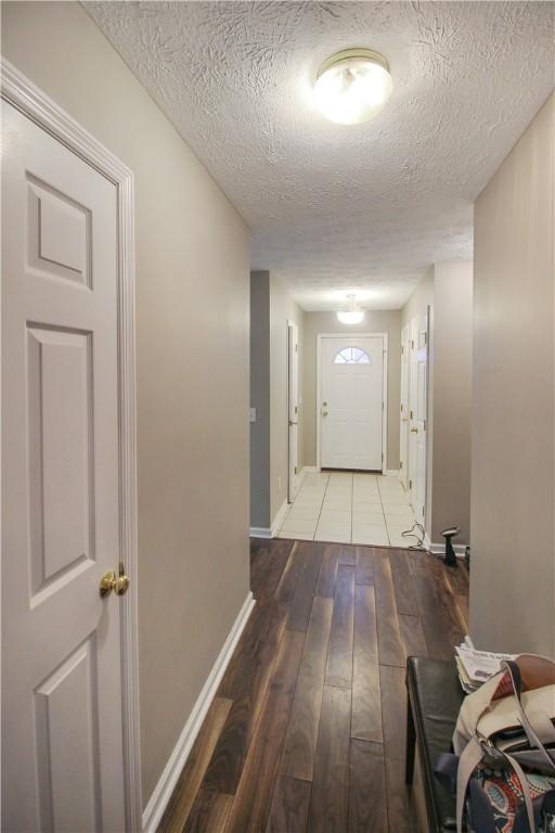 1477 N Donahue Dr Unit 3905, Auburn, AL 36830 - hall with a textured ceiling, hardwood / wood-style floors, and baseboards
