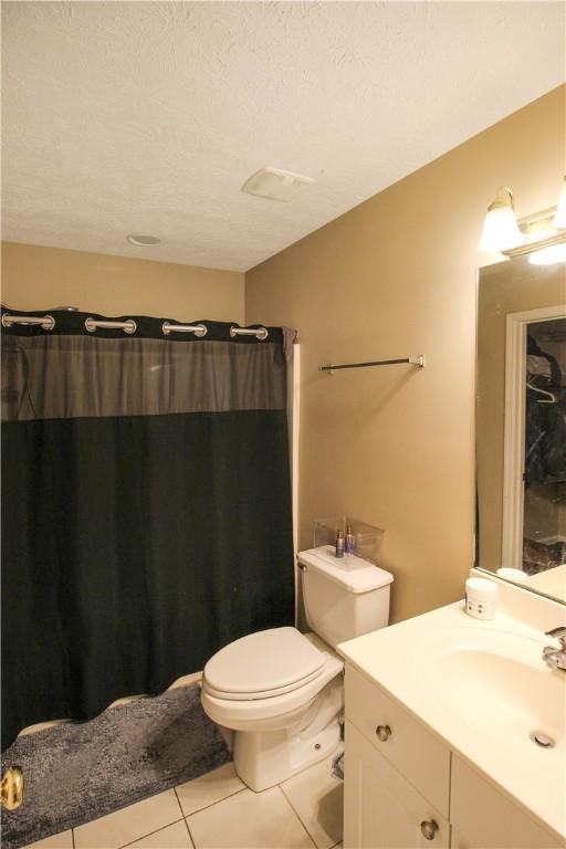 1477 N Donahue Dr Unit 3905, Auburn, AL 36830 - full bathroom with tile patterned floors, vanity, toilet, a shower with curtain, and a textured ceiling