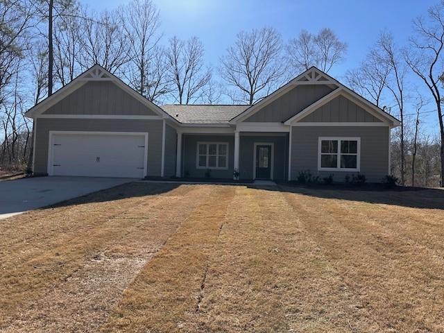 view of front of home with a garage, a front yard, board and batten siding, and driveway