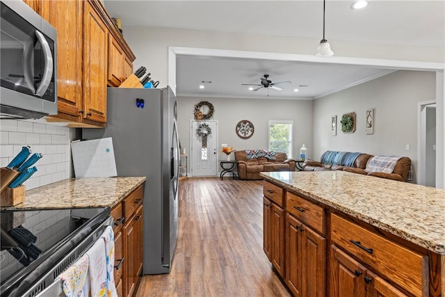 160 Indian Ln, Tallassee, AL 36078 - kitchen with stainless steel microwave, brown cabinetry, open floor plan, wood finished floors, and recessed lighting