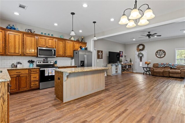160 Indian Ln, Tallassee, AL 36078 - kitchen featuring appliances with stainless steel finishes, open floor plan, tasteful backsplash, brown cabinetry, and recessed lighting