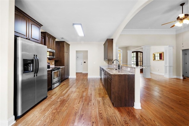 3204 Pinecrest Dr, Opelika, AL 36801 - kitchen featuring appliances with stainless steel finishes, arched walkways, dark brown cabinets, a ceiling fan, and a peninsula