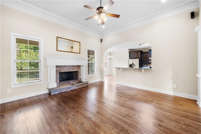 3204 Pinecrest Dr, Opelika, AL 36801 - unfurnished living room with ceiling fan, a stone fireplace, arched walkways, wood finished floors, and ornamental molding