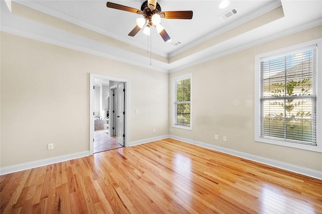 3204 Pinecrest Dr, Opelika, AL 36801 - empty room featuring a tray ceiling, crown molding, healthy amount of natural light, light wood-style floors, and ceiling fan