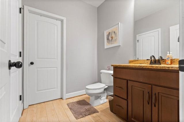 bathroom featuring vanity, wood-type flooring, and toilet