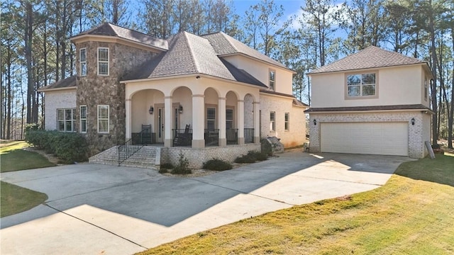 view of front of house with covered porch, a garage, and a front lawn