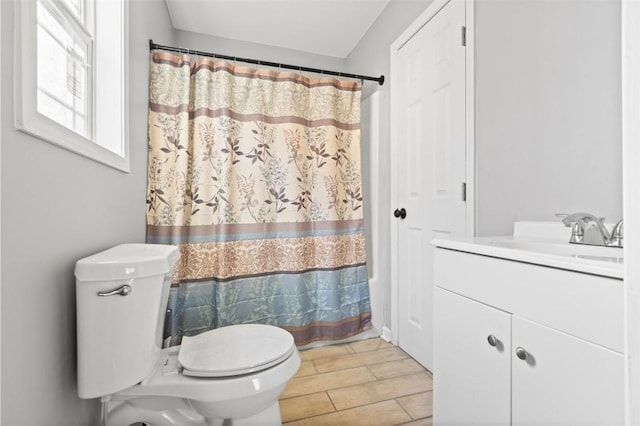 bathroom featuring vanity, toilet, and walk in shower