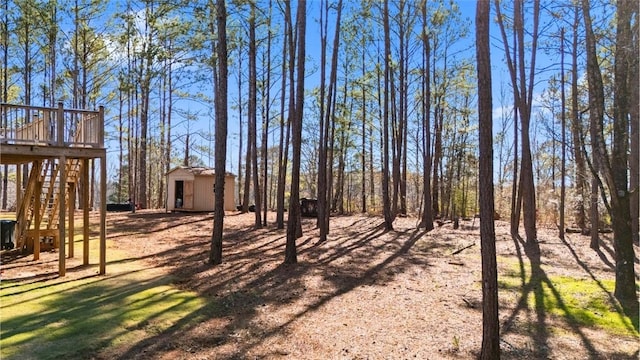 view of yard featuring a deck and a storage unit