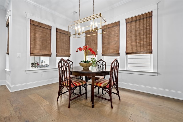 dining area with a chandelier, hardwood / wood-style floors, and ornamental molding