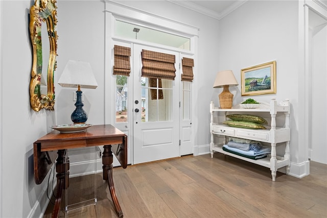 foyer entrance featuring hardwood / wood-style flooring and crown molding