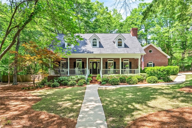 1903 N Ashe Ct, Auburn, AL 36830 - cape cod home with brick siding, a chimney, a front lawn, and covered porch