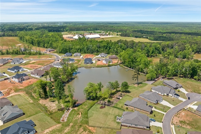 drone / aerial view featuring a water view, a forest view, and a residential view