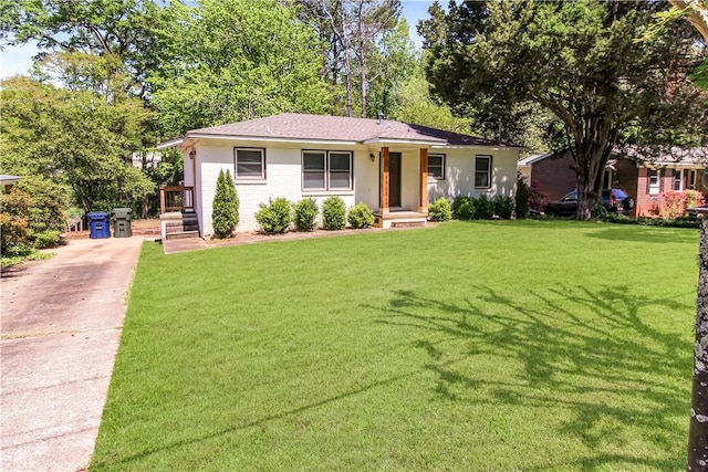 ranch-style home with concrete driveway and a front lawn