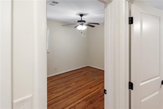 unfurnished room with visible vents, baseboards, a ceiling fan, and wood finished floors