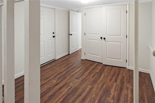 unfurnished bedroom with baseboards and dark wood-style floors