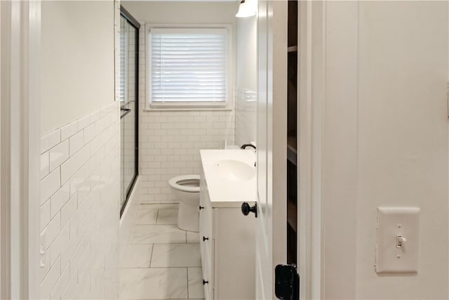 full bath with vanity, tile walls, toilet, a shower with shower door, and marble finish floor