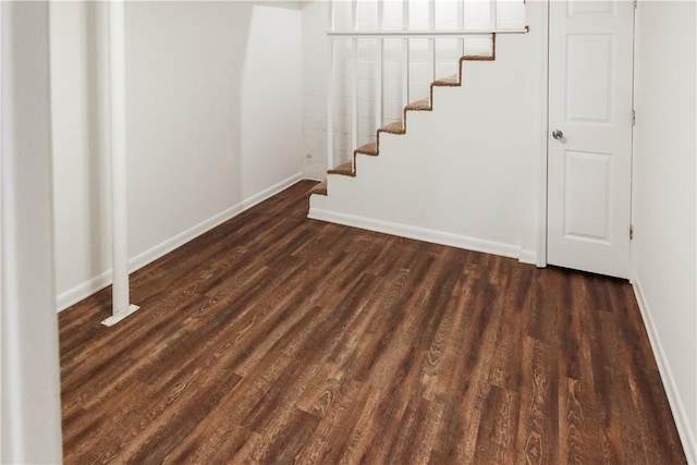basement with baseboards, wood finished floors, and stairs
