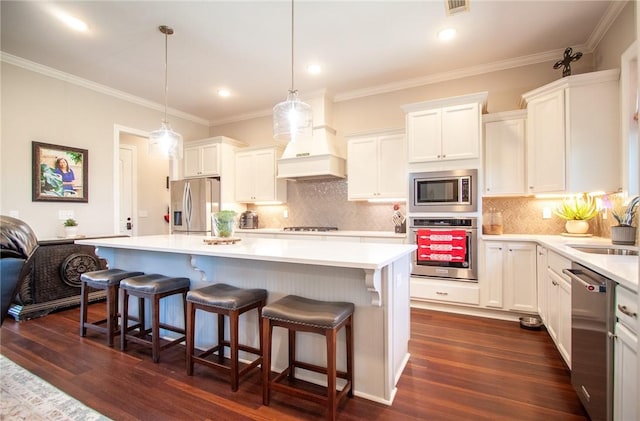 kitchen with white cabinets, a center island, sink, and appliances with stainless steel finishes