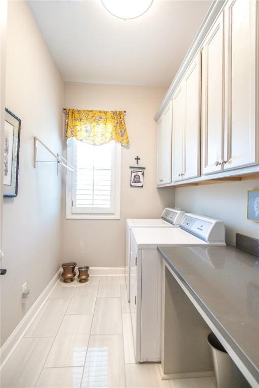 laundry area featuring cabinets, light tile patterned floors, and washer and dryer