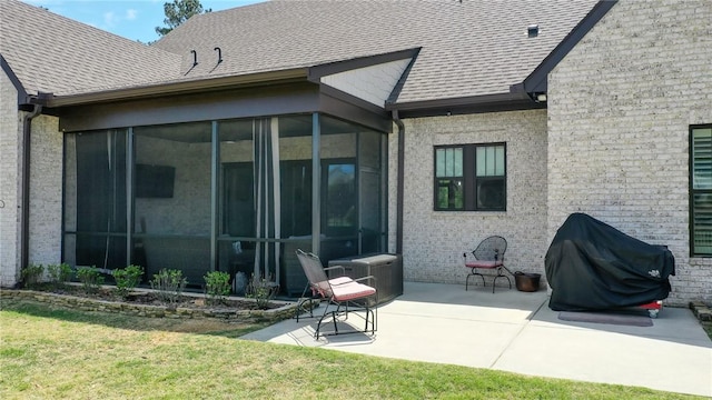 back of property with a lawn, a patio area, and a sunroom