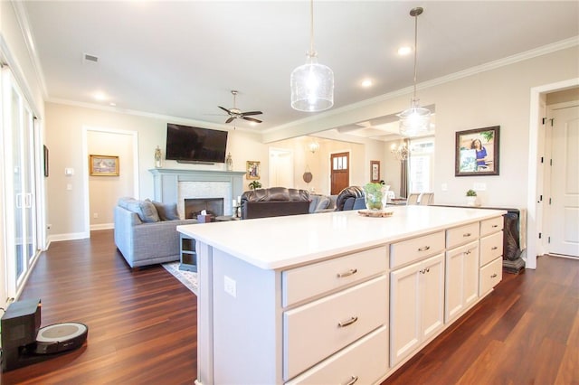 kitchen featuring a center island, dark wood-type flooring, ornamental molding, decorative light fixtures, and white cabinetry