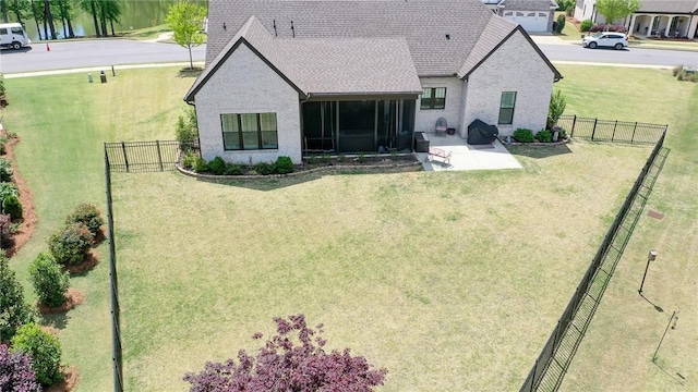 rear view of house with a yard, a patio, and a sunroom