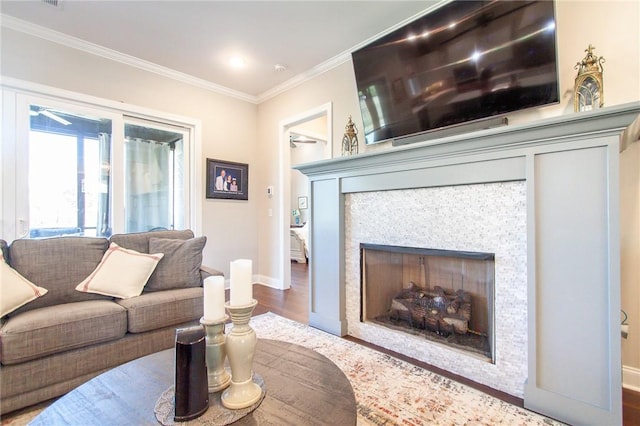 living room with hardwood / wood-style floors, ornamental molding, and a tiled fireplace