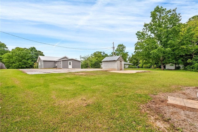 view of grassy yard with an outdoor structure