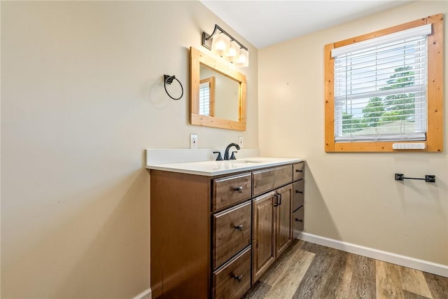 bathroom with baseboards, wood finished floors, and vanity