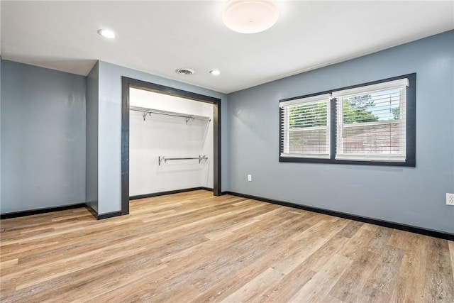 unfurnished bedroom featuring light wood finished floors, baseboards, a closet, and recessed lighting