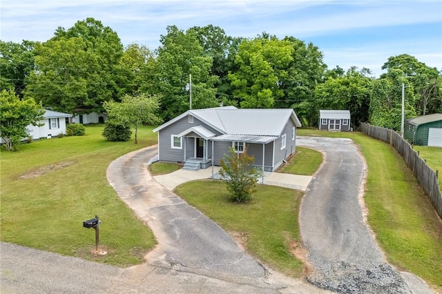 bungalow-style home featuring asphalt driveway and metal roof